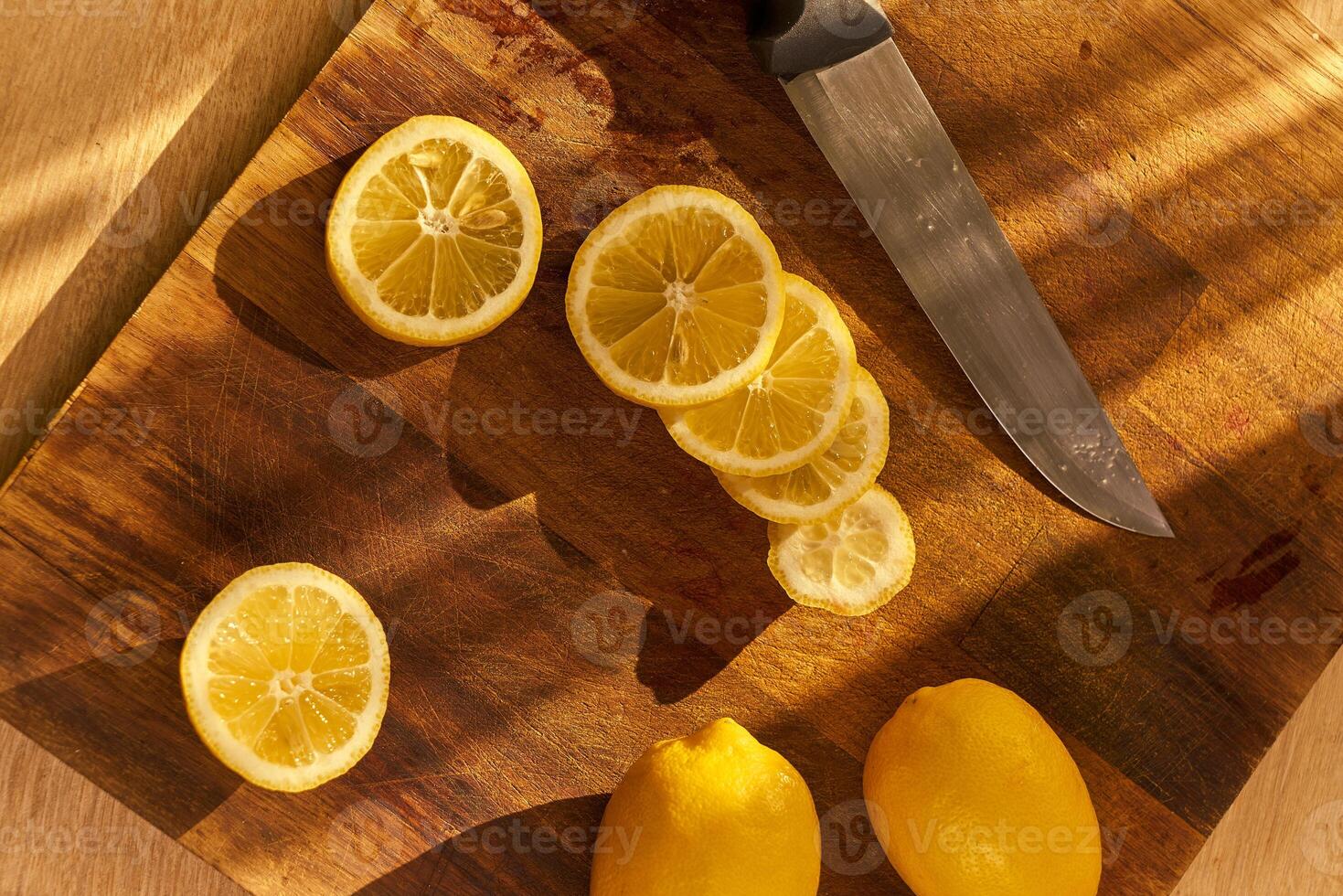 Slices of organic lemon on a wooden cutting board photo