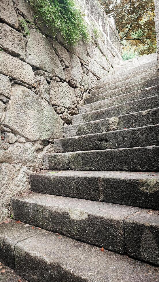 An ancient stone staircase leading upwards. The concept of a difficult rocky path to success, overcoming difficulties. photo