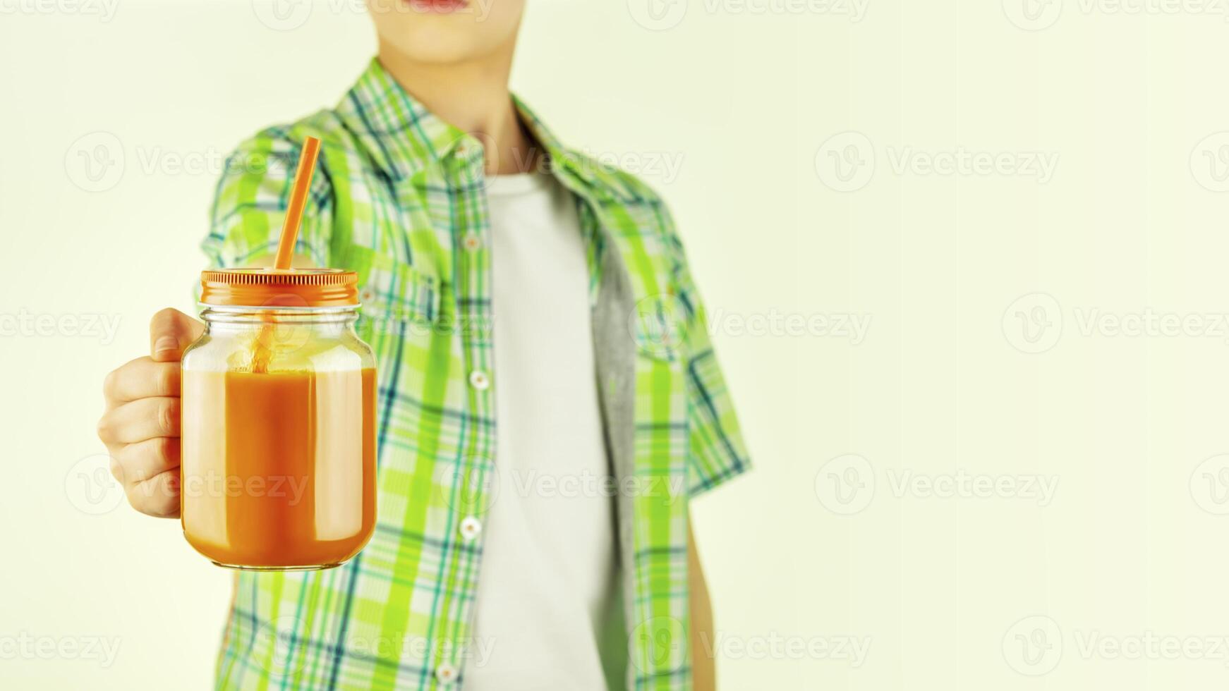 teenager holding carrot juice in a glass mug with copy space photo