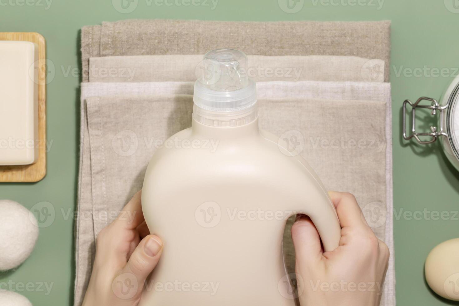 Female hands hold bottle with washing gel on a textile napkins photo
