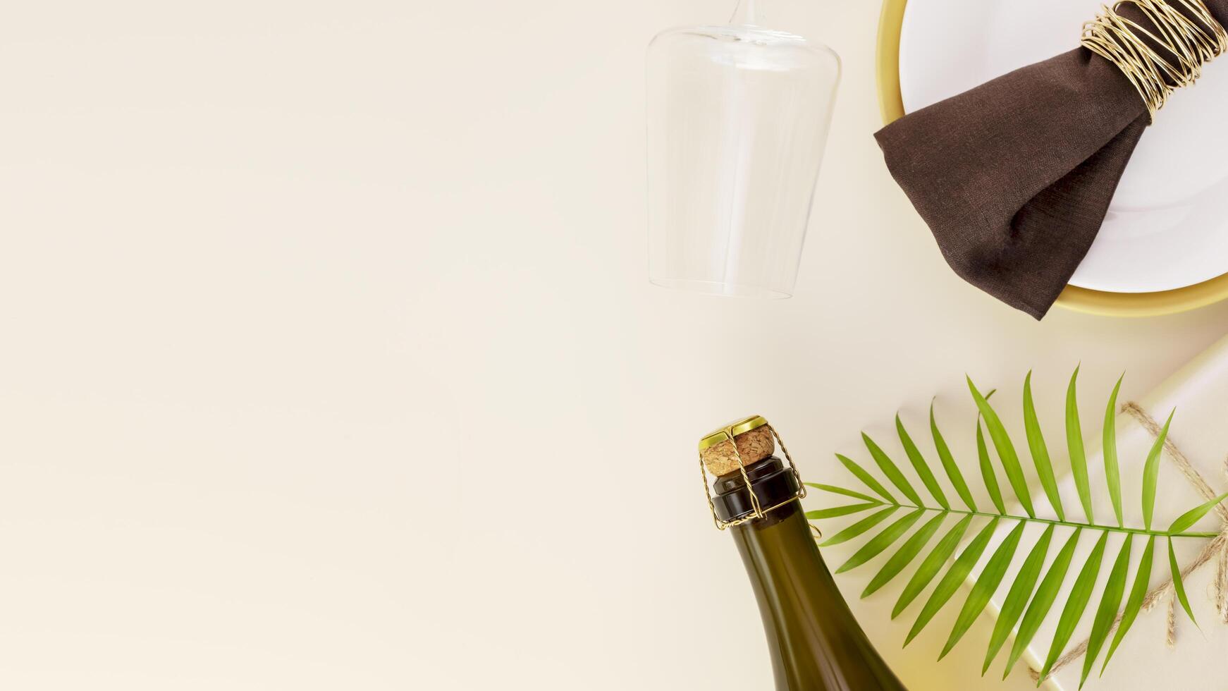 Gift with palm leaf, bottle of champagne and glass on a beige background photo