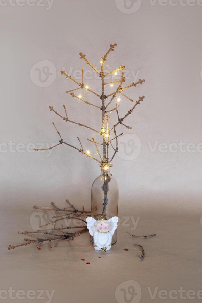 A crumbling Christmas tree with broken branches, a toy angel and drops of blood photo