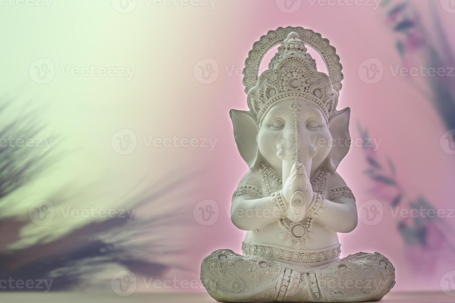 White sculpture of Lord Ganesha on a gradient background with copy space photo