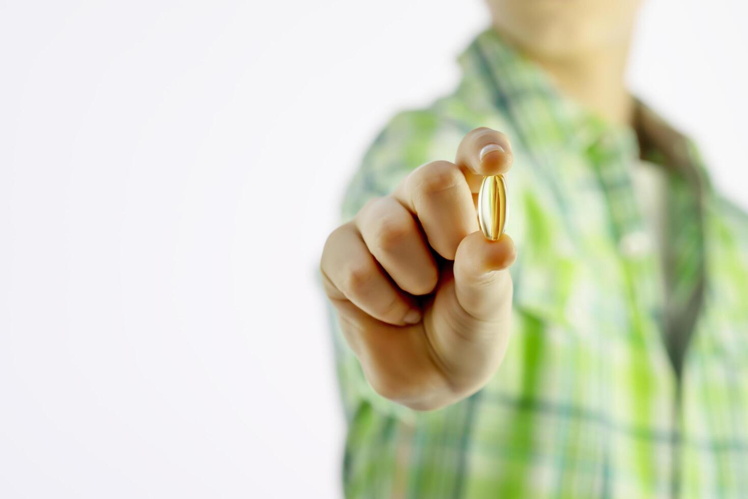 Boy holding gel capsule on a white background with copy space photo