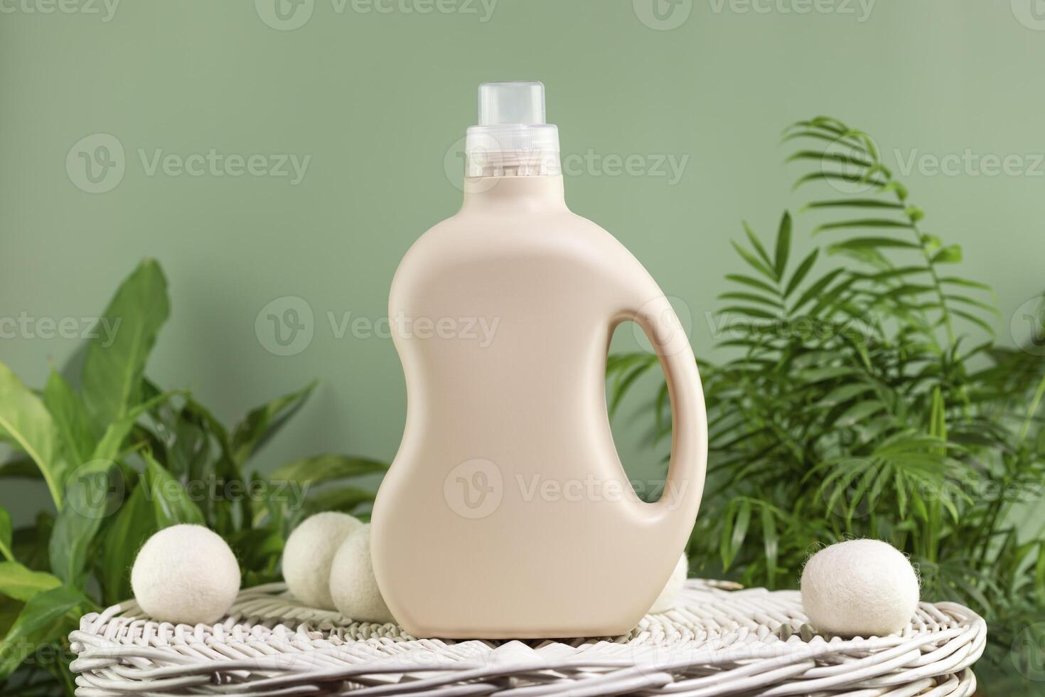 Bottle of washing gel or fabric softener on a white laundry basket photo