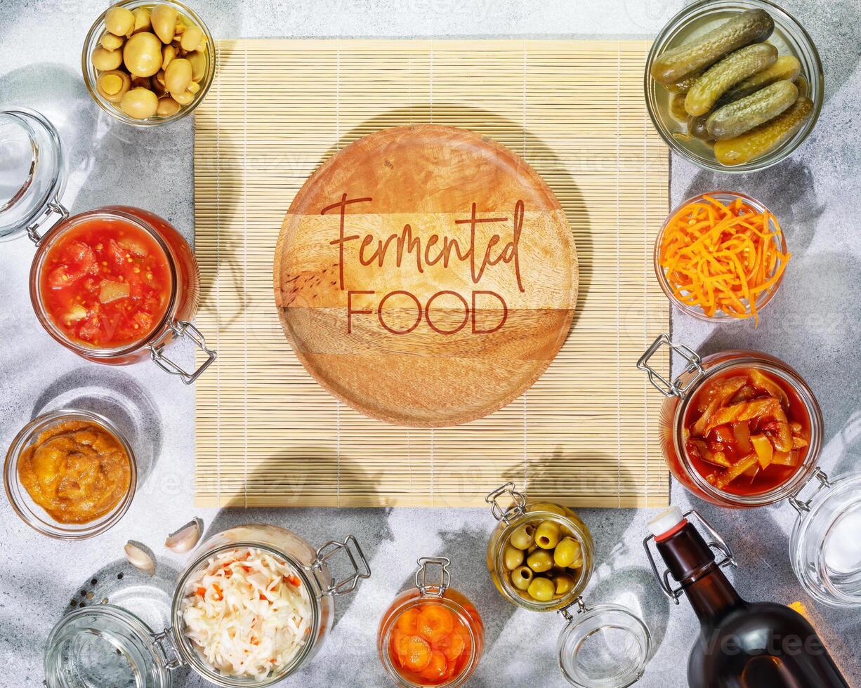 Fermented products vegetables, mushrooms in glass jars, bottle with beer photo