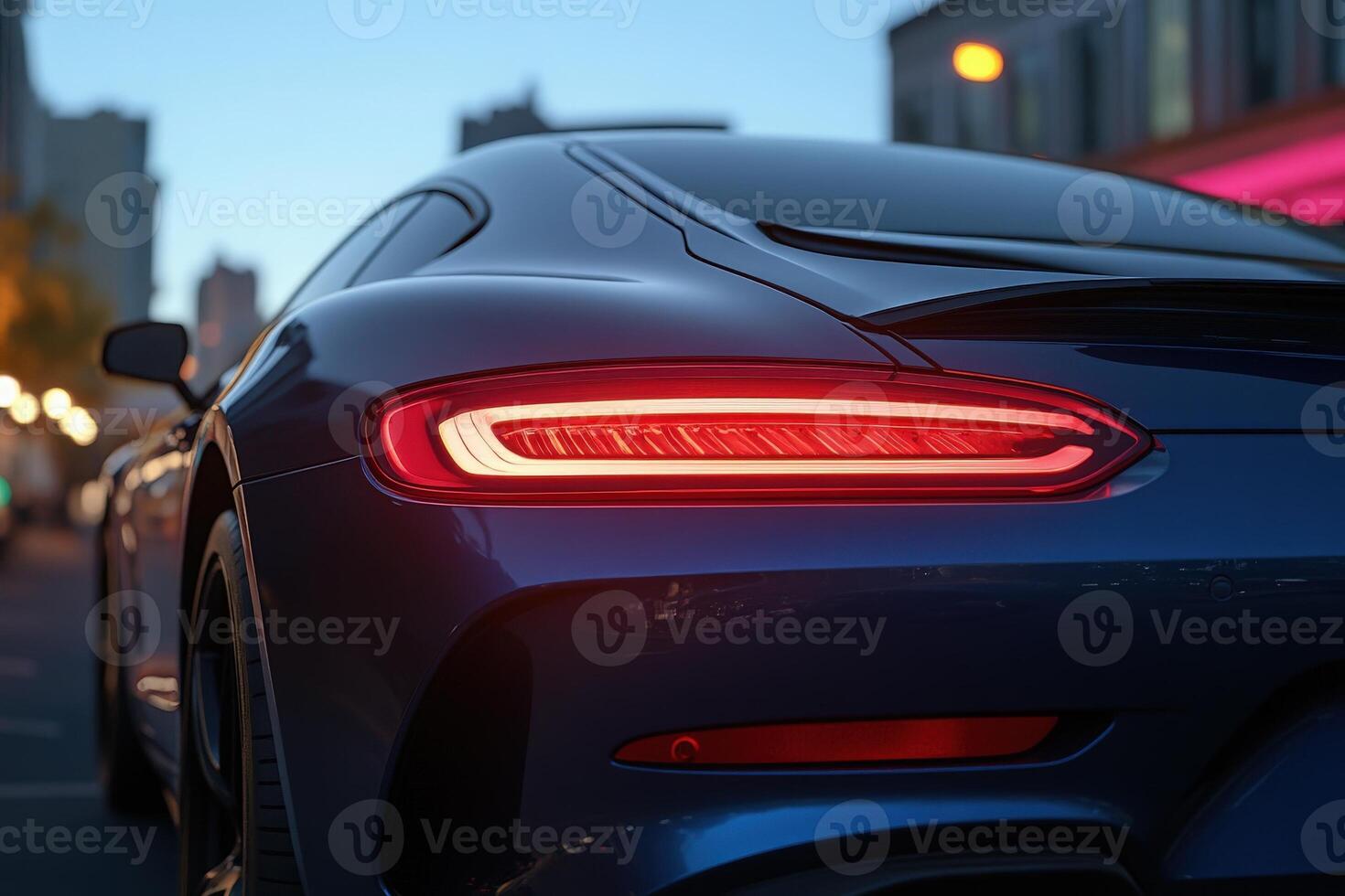 The sleek tail light glows brilliantly, reflecting the warm hues of the city, highlighting luxury and modern design. photo