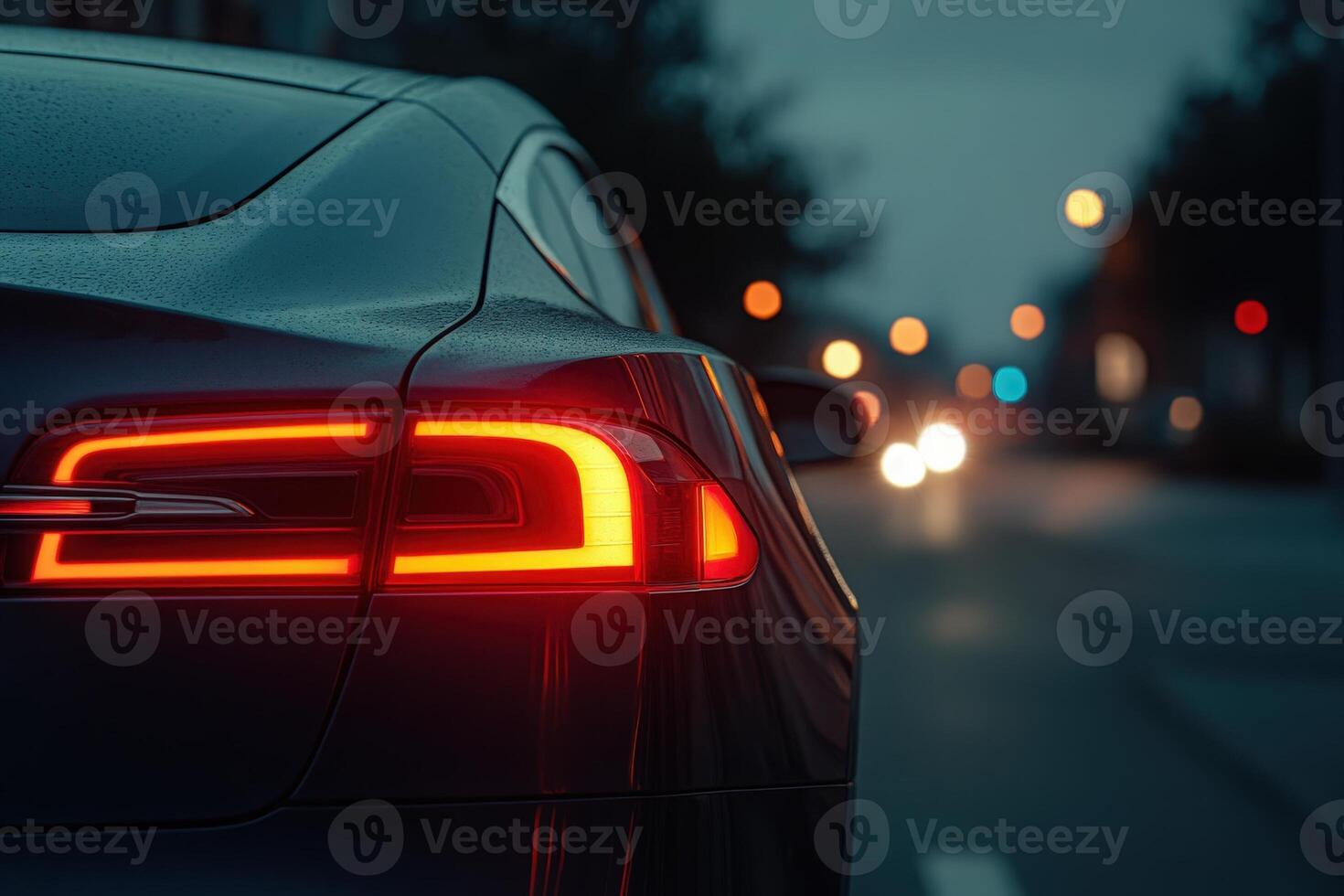 A luxury cars tail light illuminates the evening, casting a warm glow against a blurred backdrop of city lights. photo