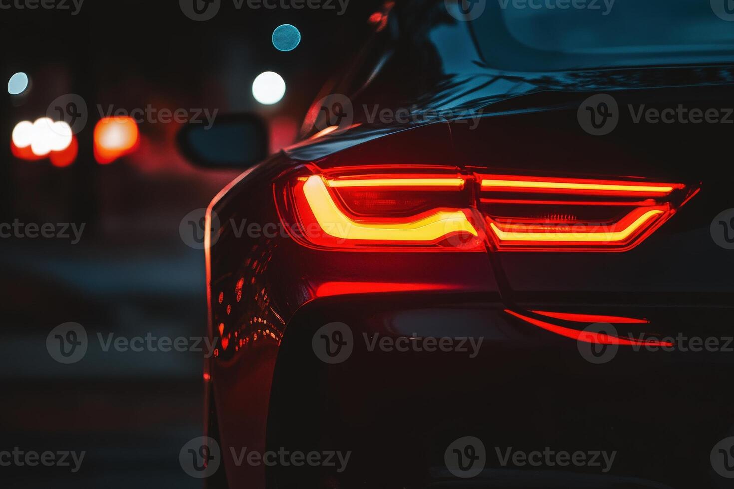 The glow of a luxury cars tail light illuminates the night, showcasing sleek design and modern elegance against a blurred backdrop of city lights. photo