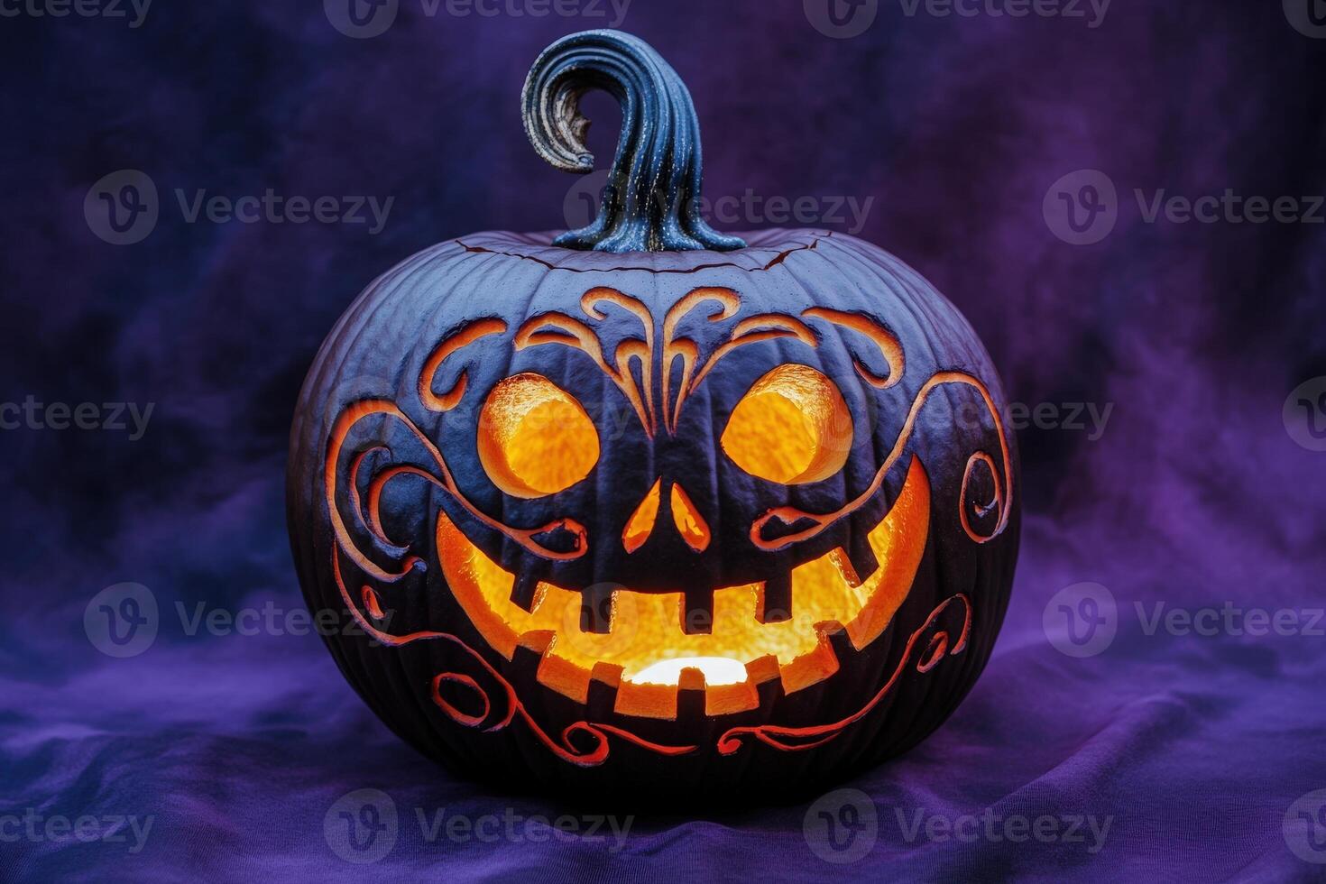 A beautifully carved pumpkin features an intricate design, illuminated from within, casting a warm glow in the dark setting. photo
