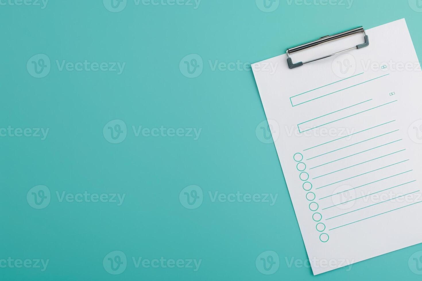 A feedback form is neatly placed on a clipboard, ready to gather insights, featuring blank spaces for responses on a vibrant turquoise surface. photo