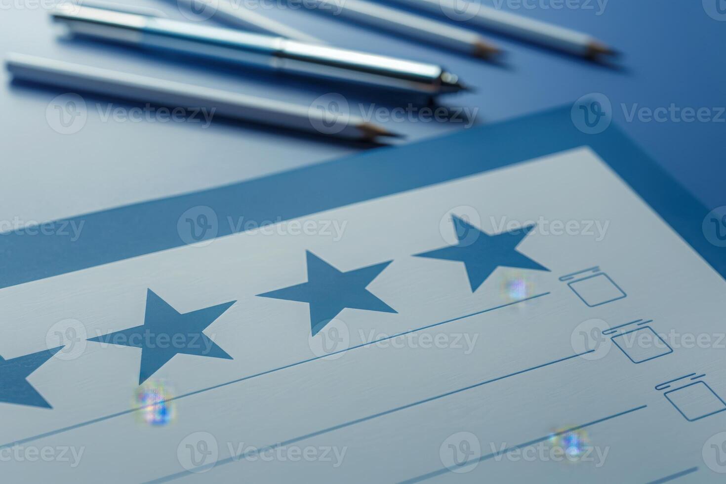 A neatly arranged feedback form featuring five stars and checkboxes sits on a smooth background, complemented by pens prepared for user input. photo