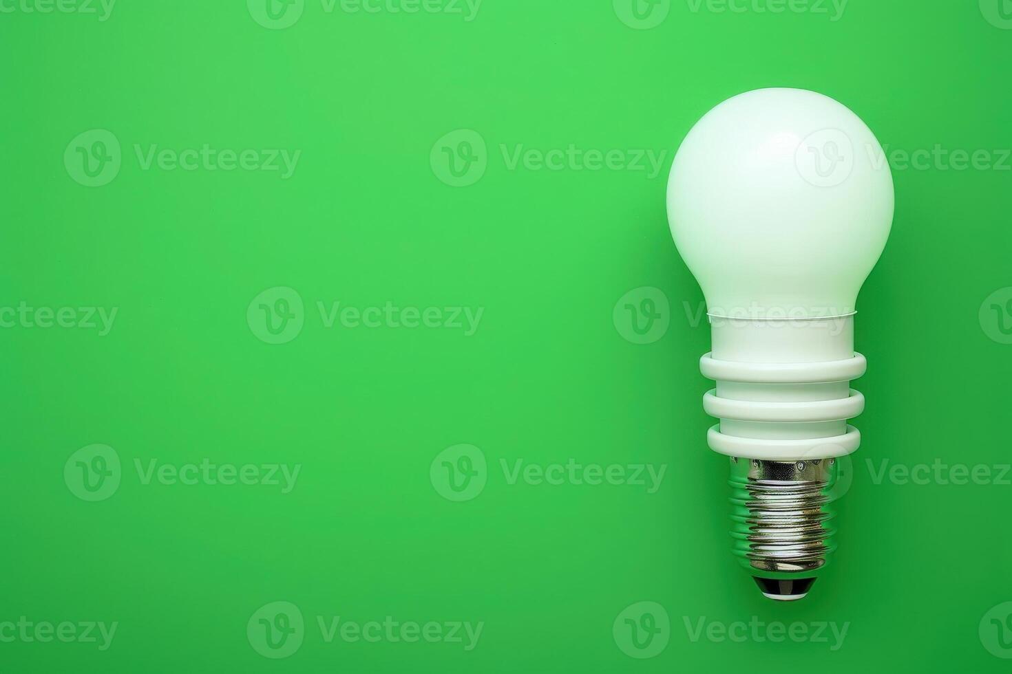 A light bulb rests against a vivid green backdrop, symbolizing innovative energy-saving solutions and eco-friendly practices. photo