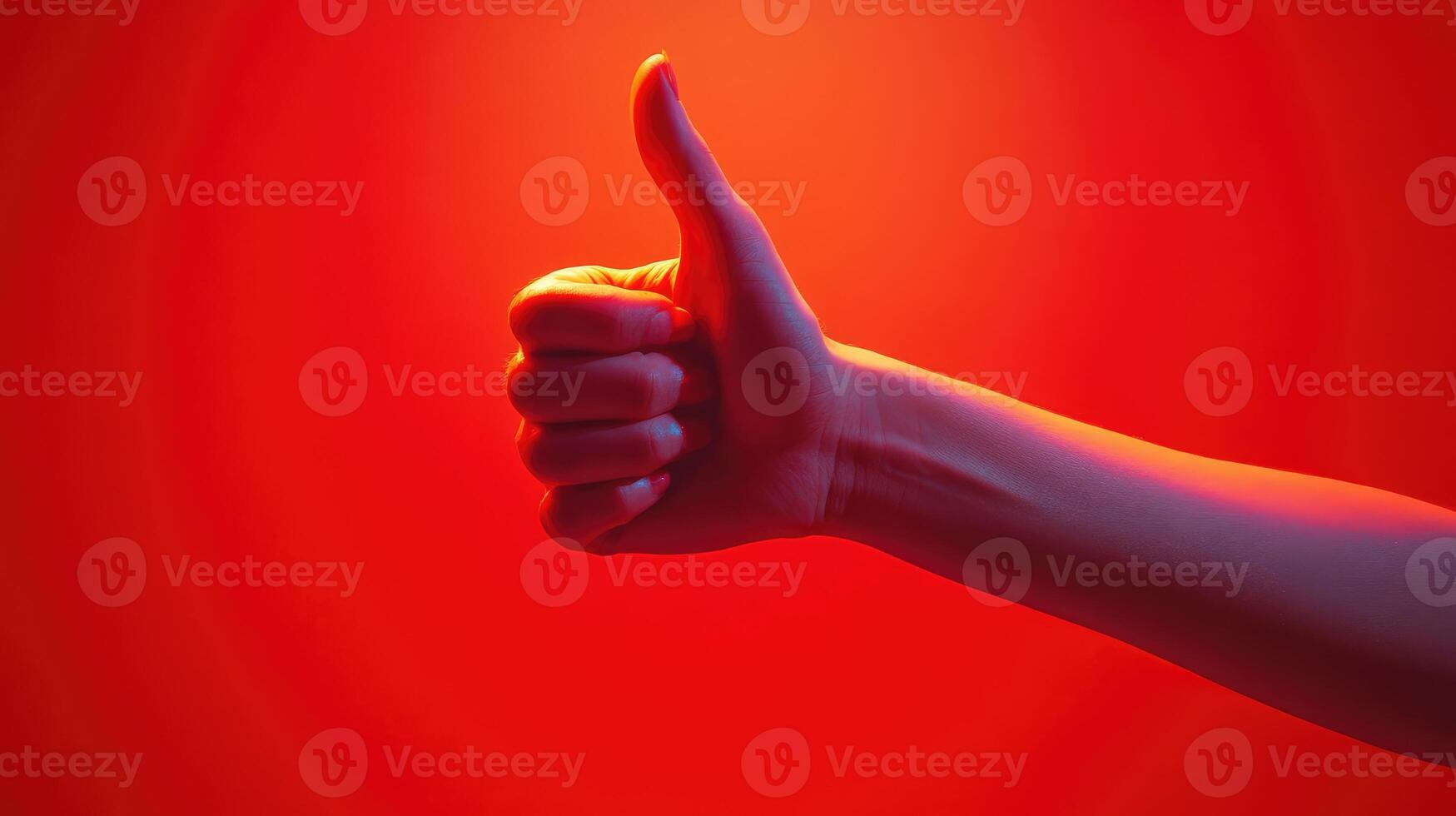 A Hand Giving a Thumbs Up Gesture Against a Red Background photo