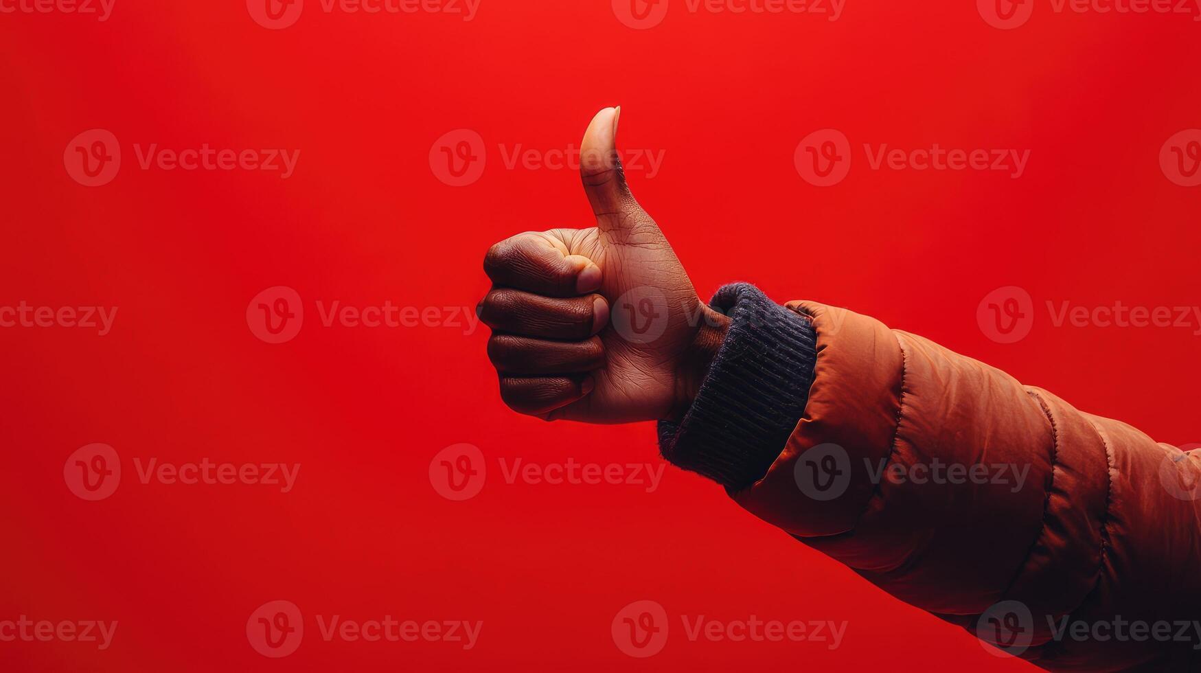 A Person's Arm With Thumbs Up Against a Red Background photo