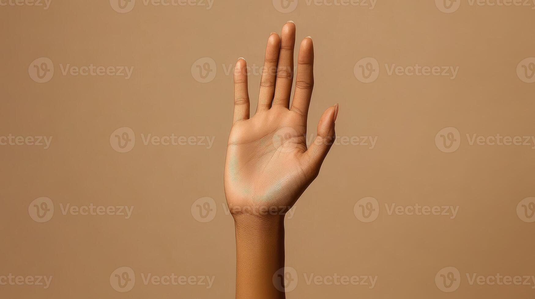 Open Hand with Spread Fingers Against a Tan Background photo