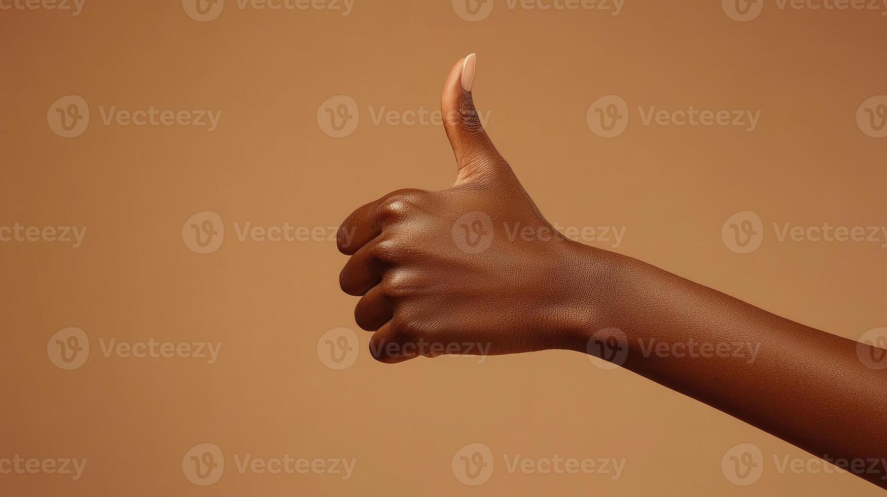 Close-up of a Brown Hand Giving a Thumbs Up Gesture photo