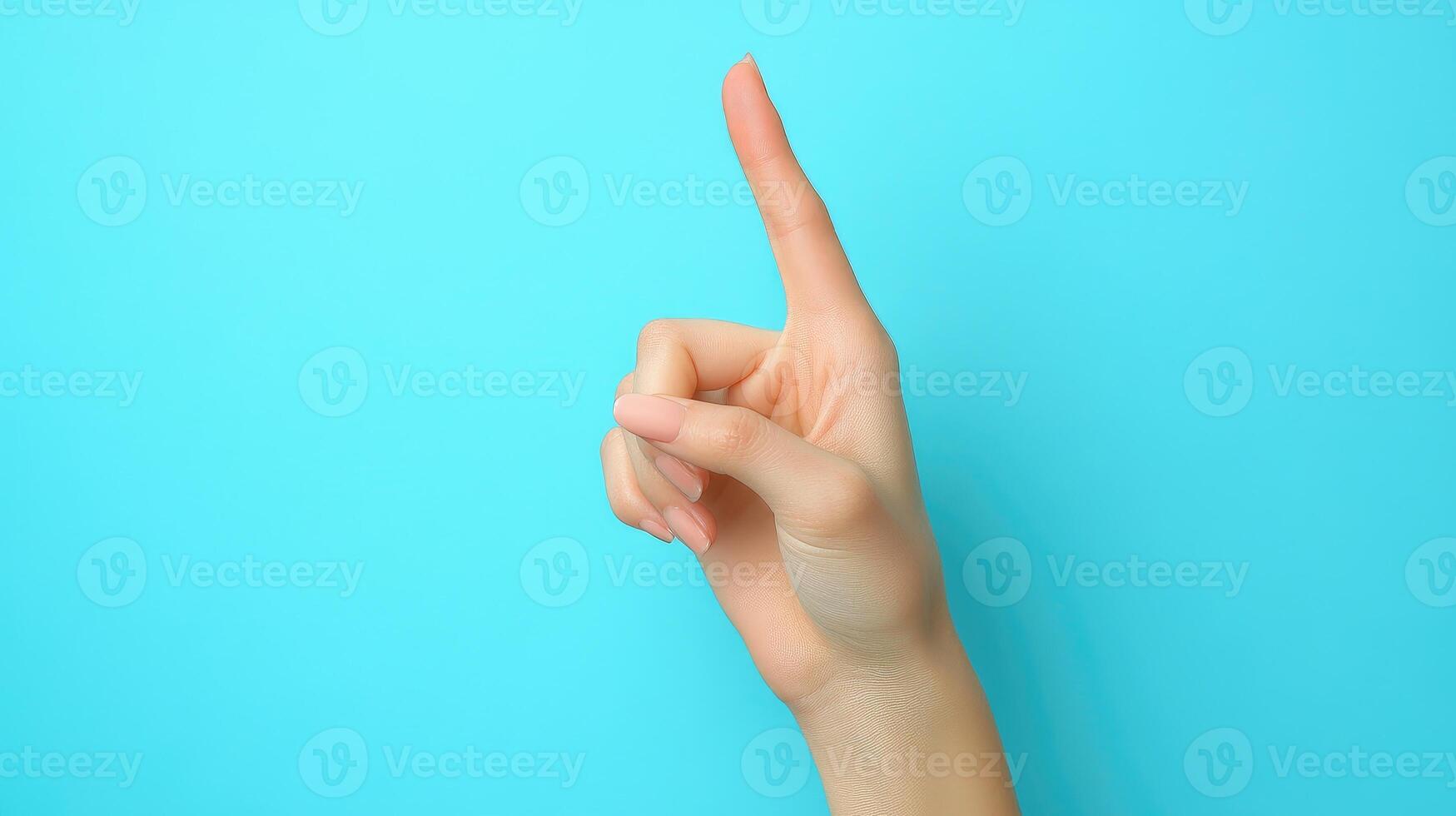 A Woman's Hand with Finger Pointing Upwards Against a Light Blue Background photo