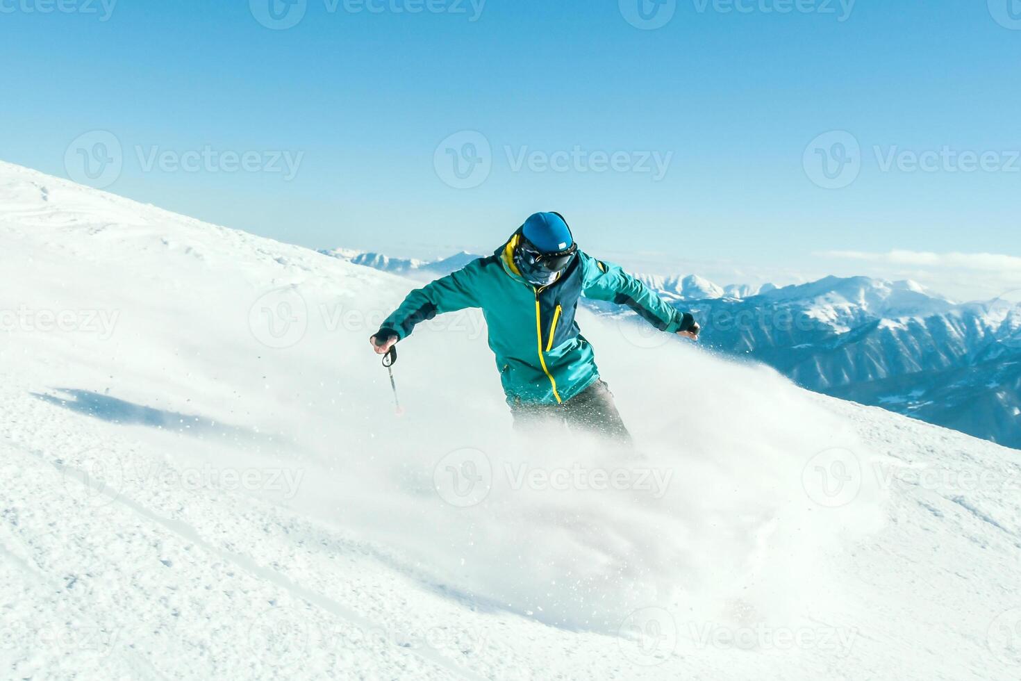 Professional caucasian skier at full speed ski downhill fast motion spray on fresh snow do carving in ski resort while training for competition in ski resort with sunny blue mountains background photo