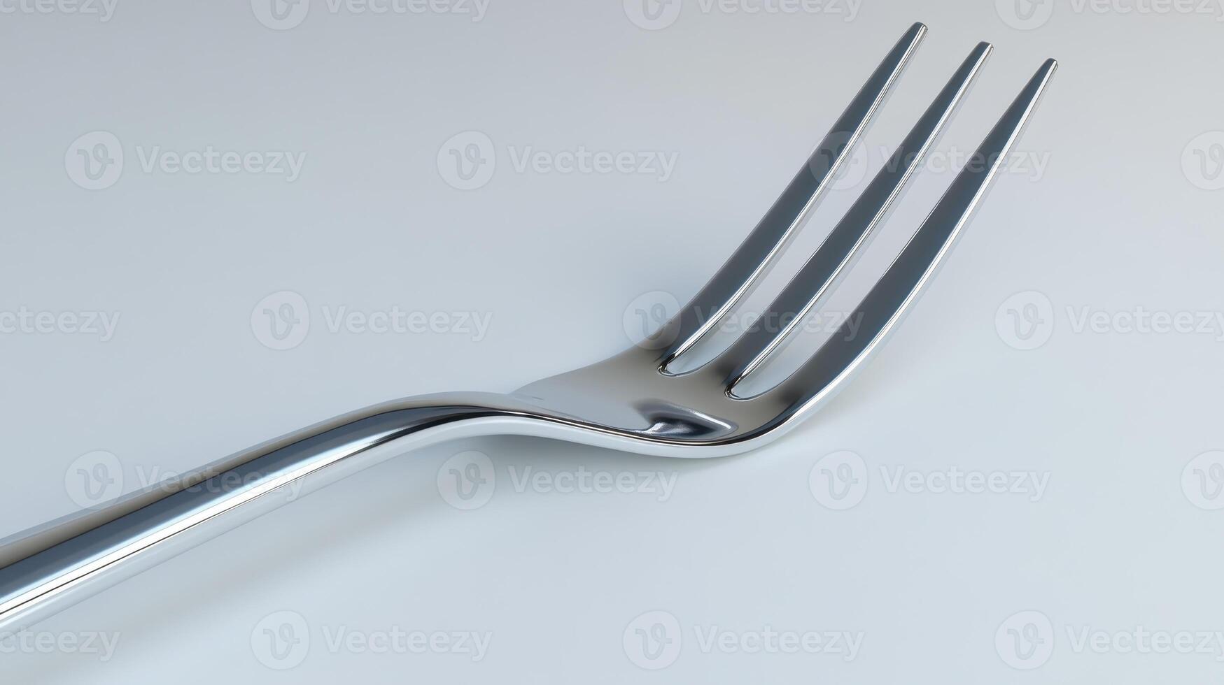 Close-up of a stainless steel fork resting on a smooth surface in bright light photo