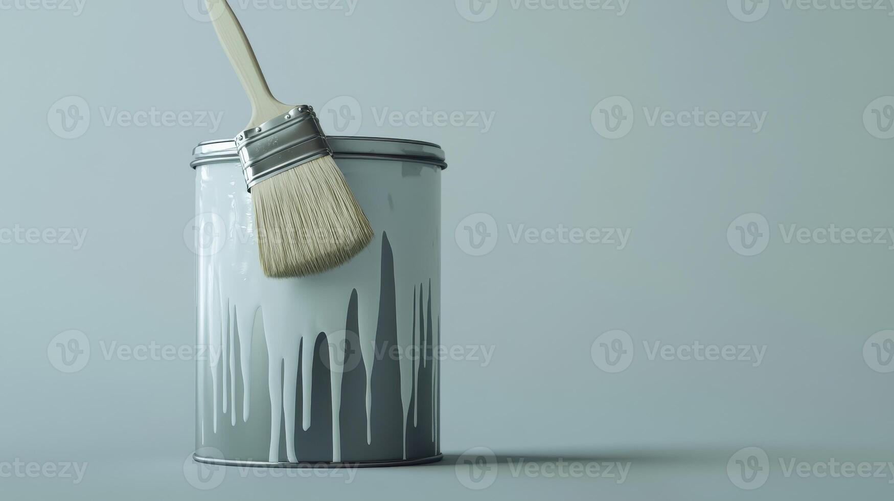 A paintbrush rests on the rim of a can with gray paint, showcasing dripping paint against a gray backdrop photo