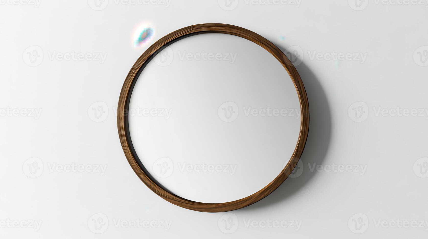 A simple round mirror with a wooden frame hanging on a white wall in a bright room photo