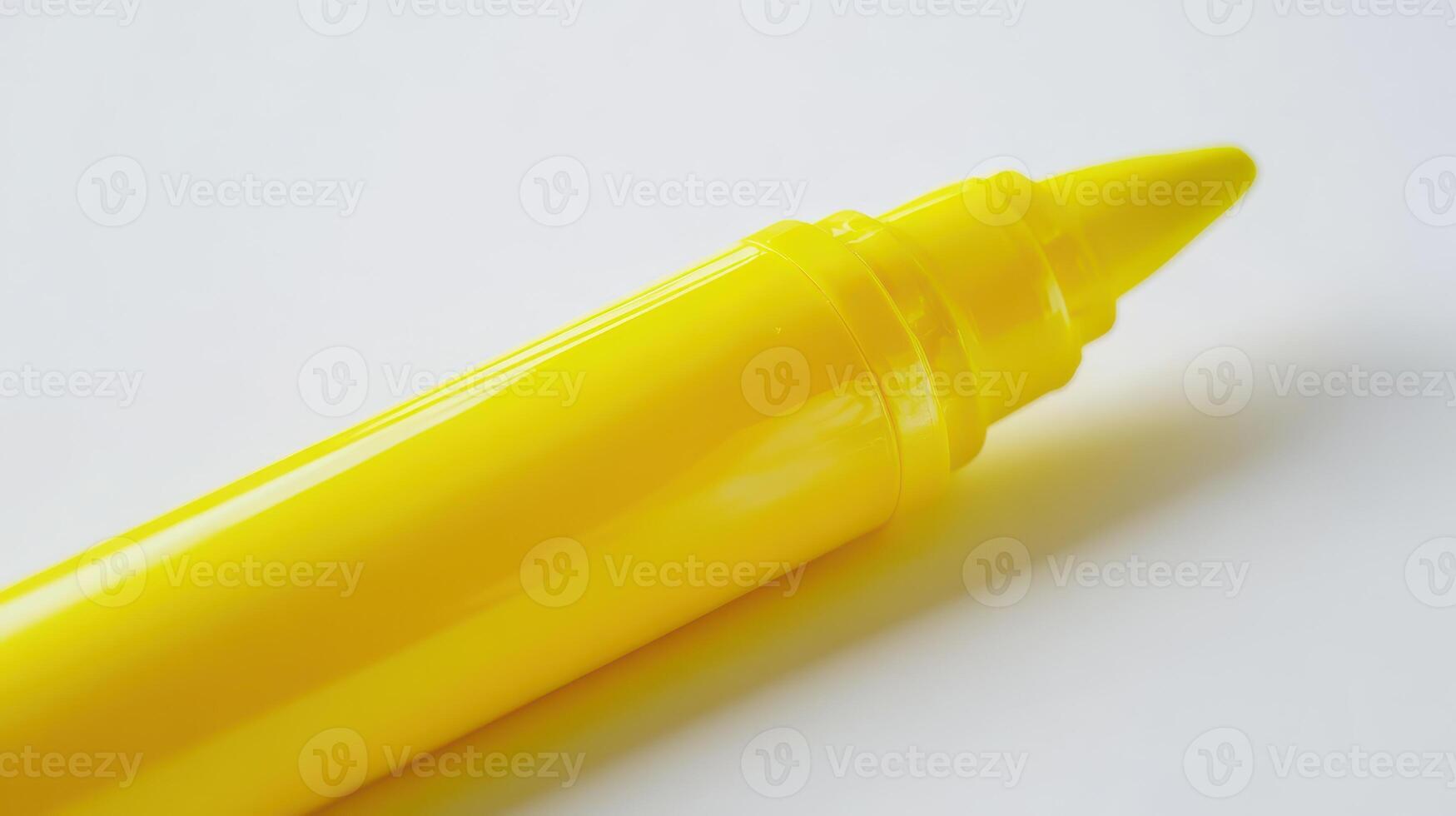 Yellow highlighter pen resting on a clean white surface during the day photo