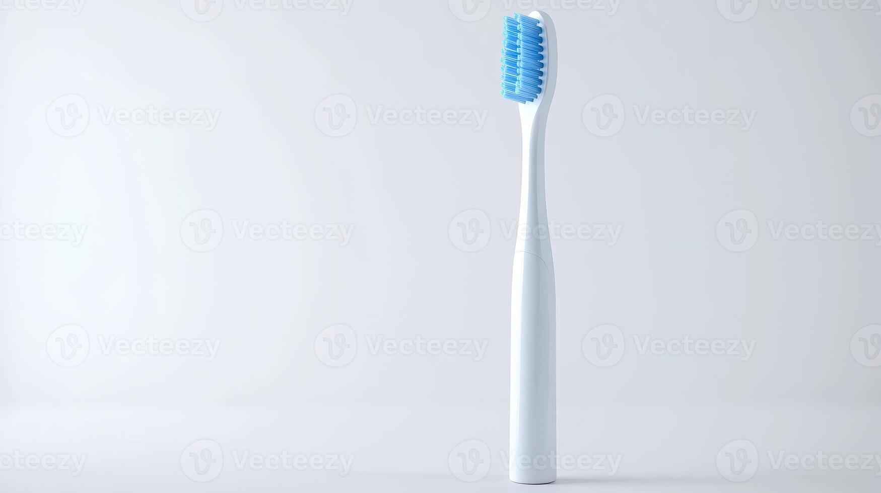 A simple white toothbrush with blue bristles standing upright against a plain background photo