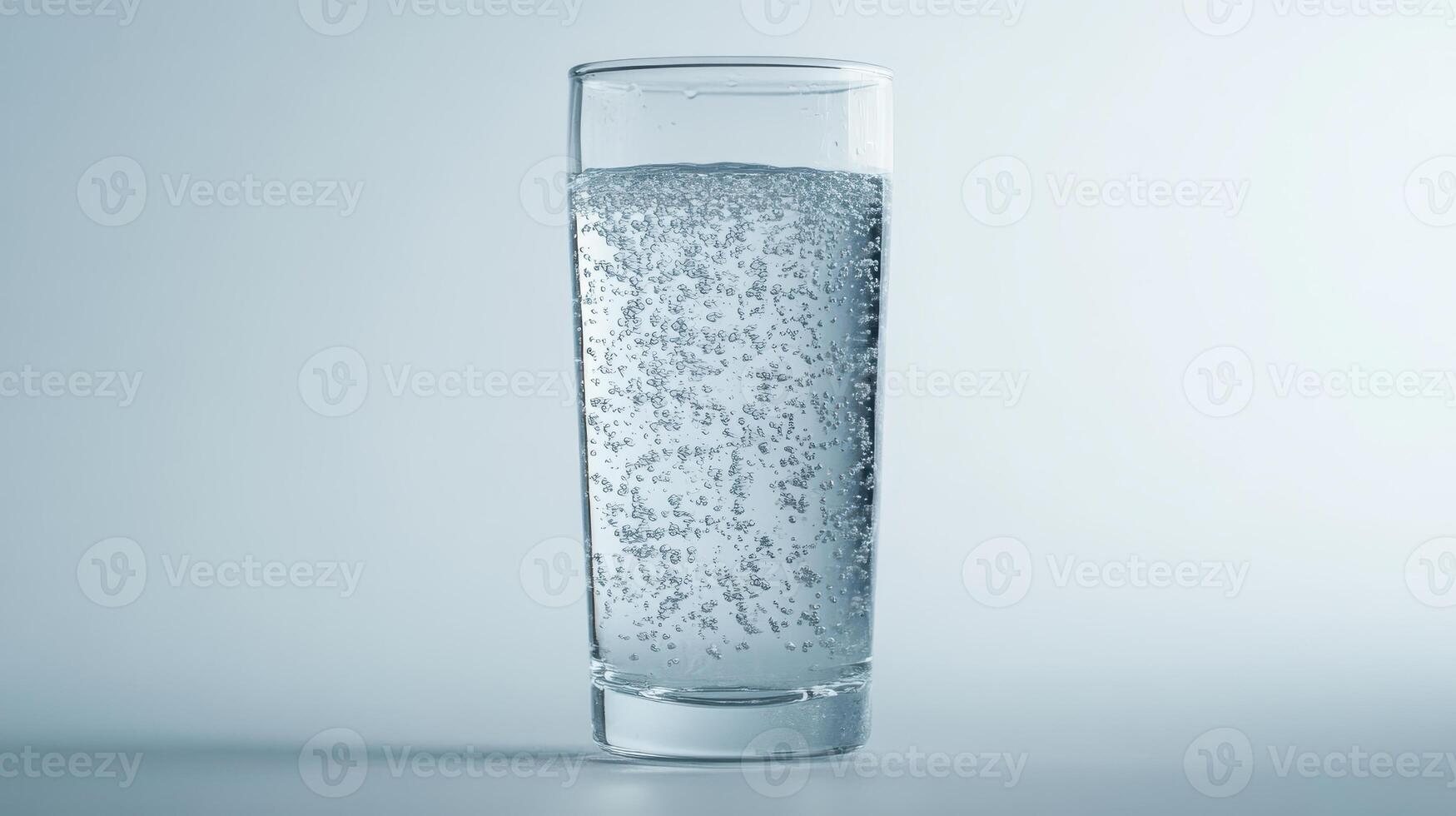 Sparkling water in a clear glass on a light background photo