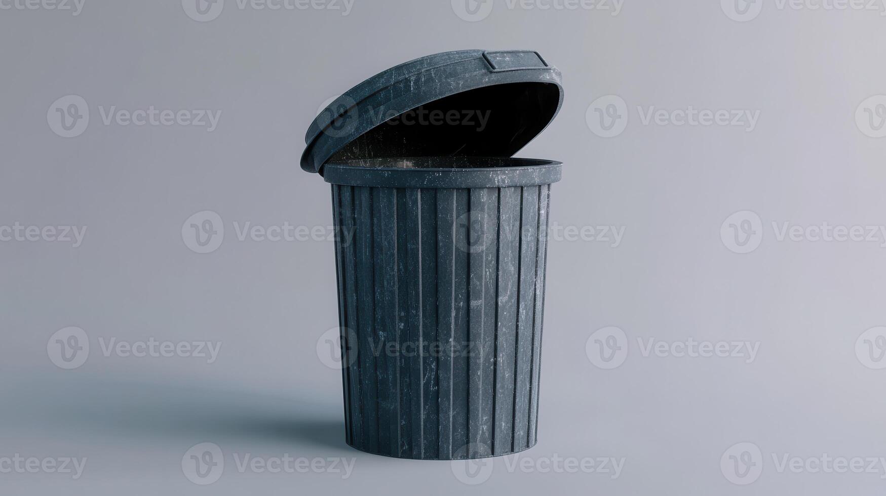 A simple gray trash can with an open lid, set against a neutral background in a clean, well-lit environment photo