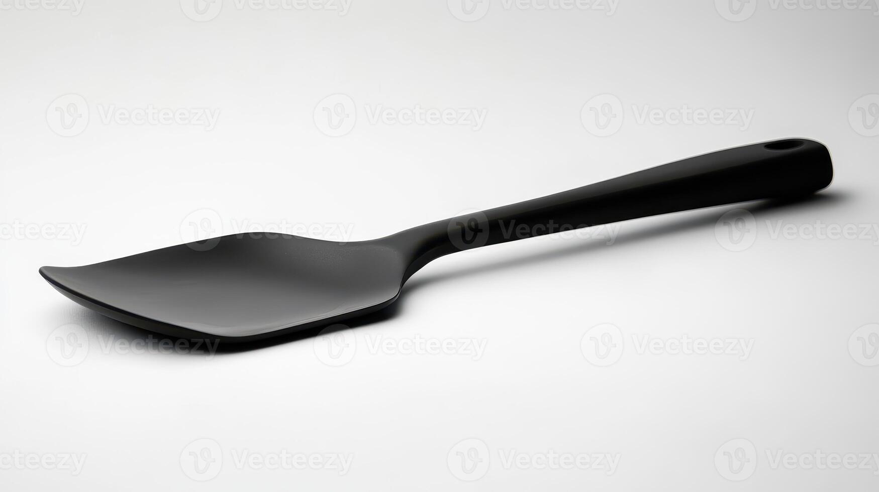 Black spatula resting on a neutral background, showcasing its sleek design and kitchen utility for cooking and serving food photo