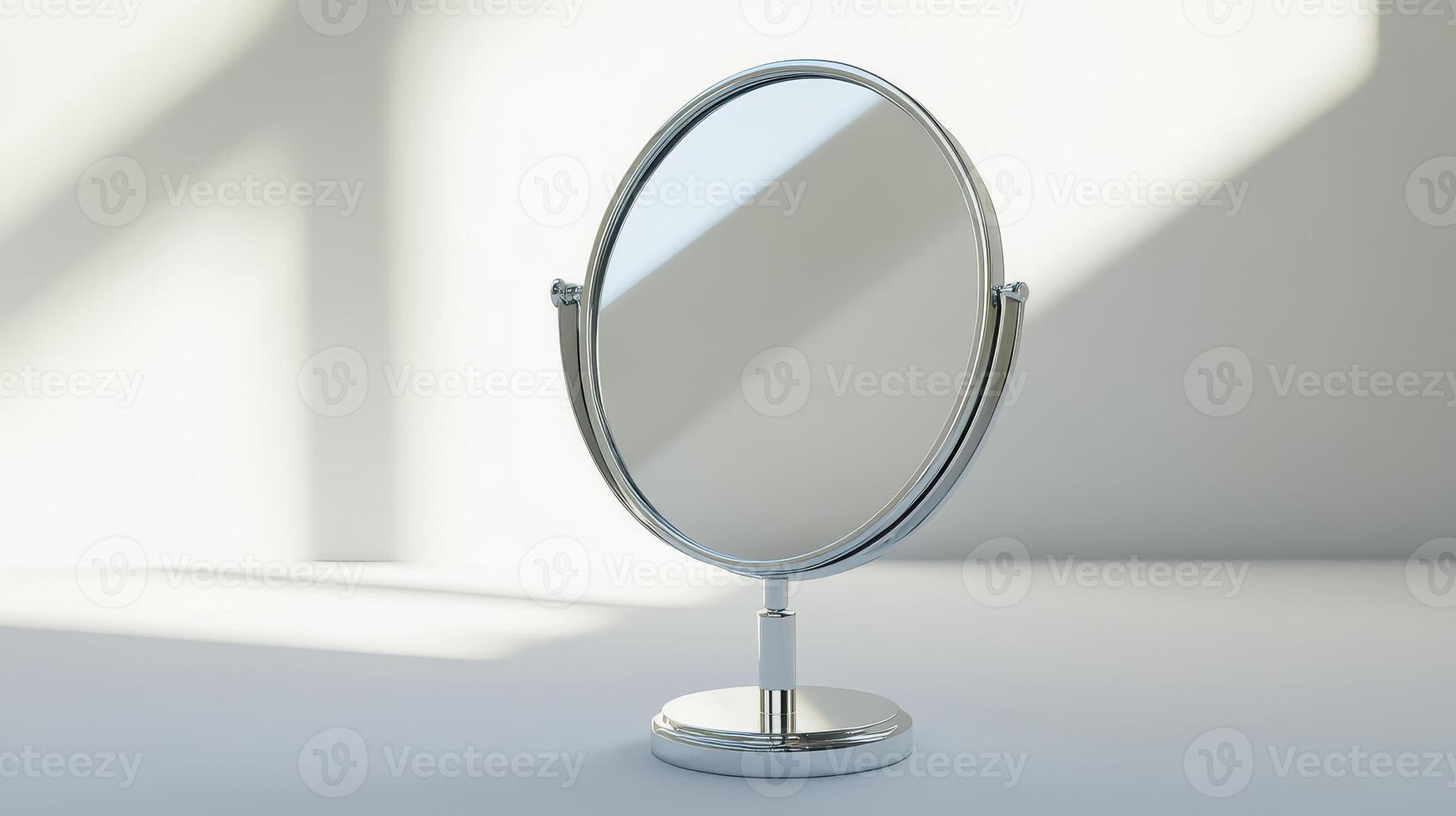 A silver tabletop mirror reflecting soft natural light in a minimalist setting photo