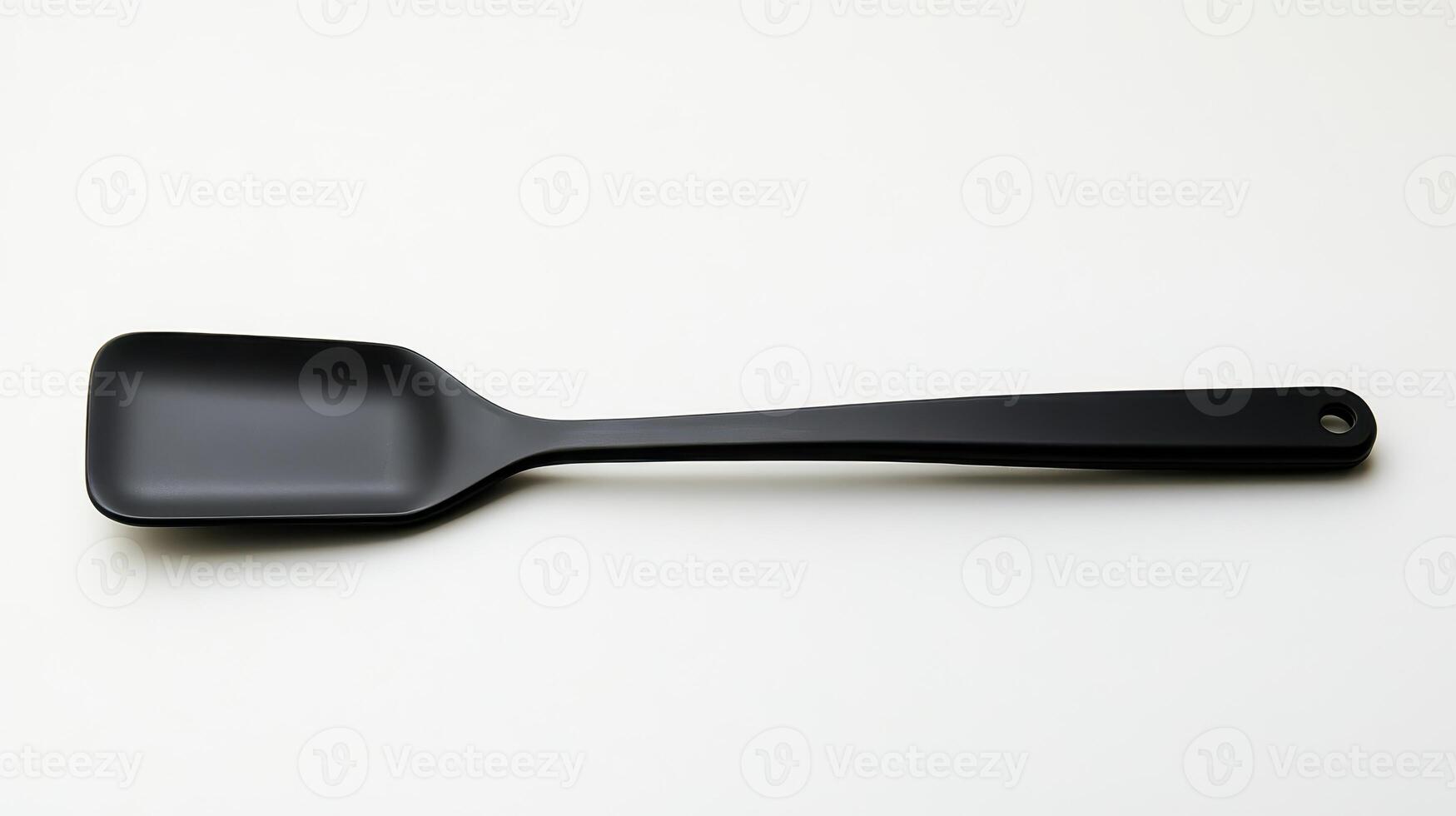 A simple black silicone spatula placed on a light surface in a well-lit kitchen environment photo