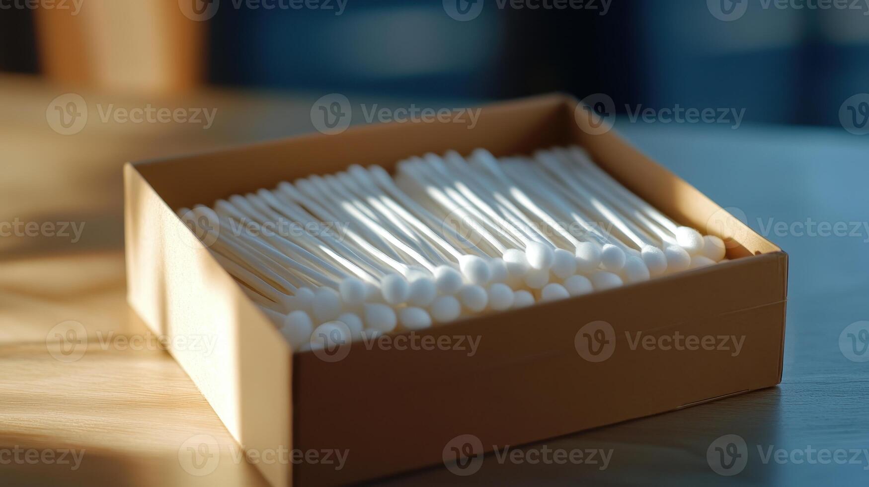 Cotton swabs neatly arranged in a box on a wooden table with soft sunlight illuminating the scene photo