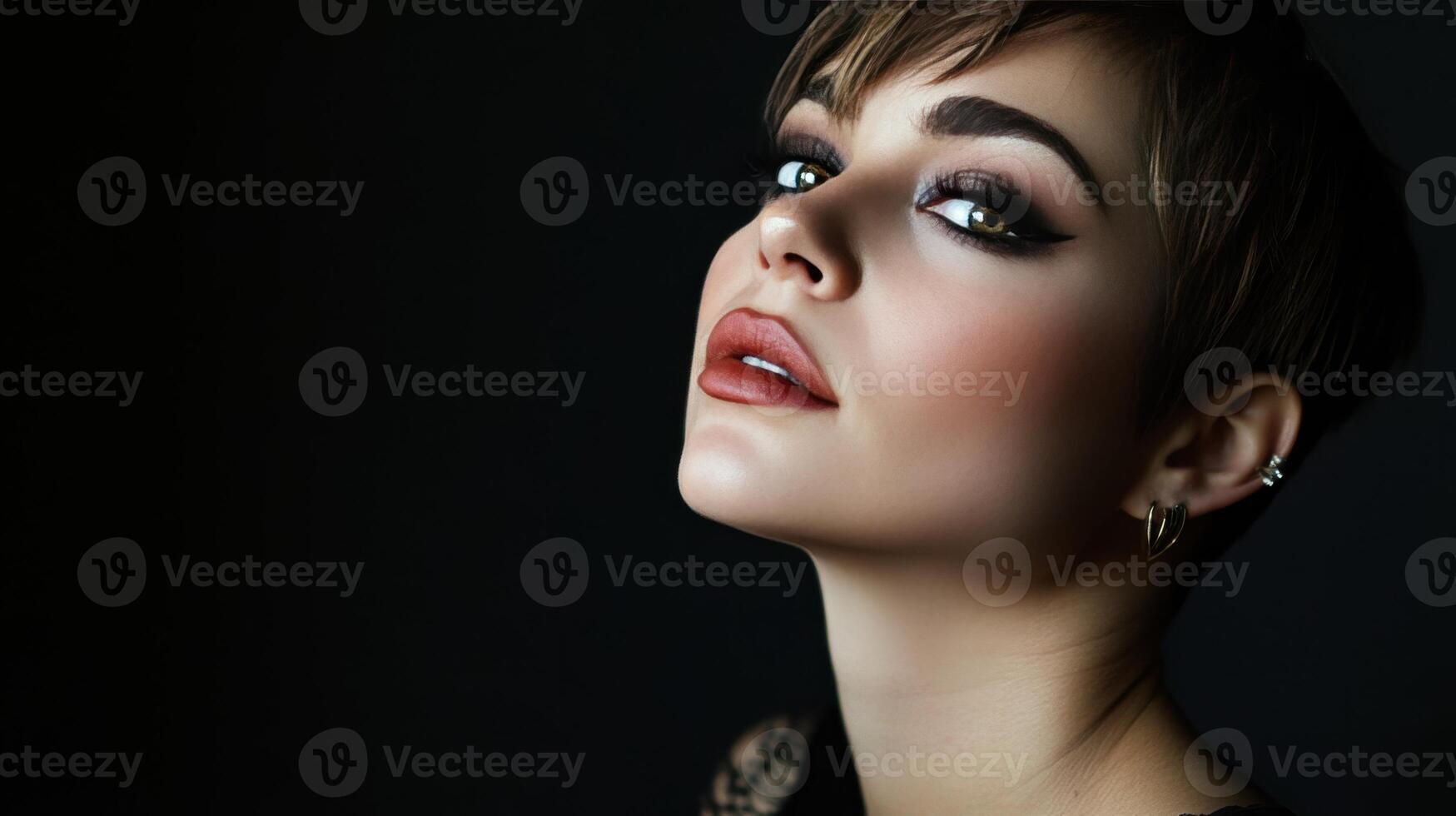 Portrait of a woman with short hair showcasing elegant makeup against a dark background in a dimly lit setting photo