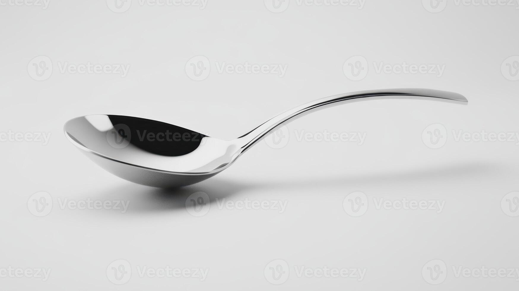 A shiny metal spoon resting on a clean white surface, showcasing its smooth curves and polished finish photo