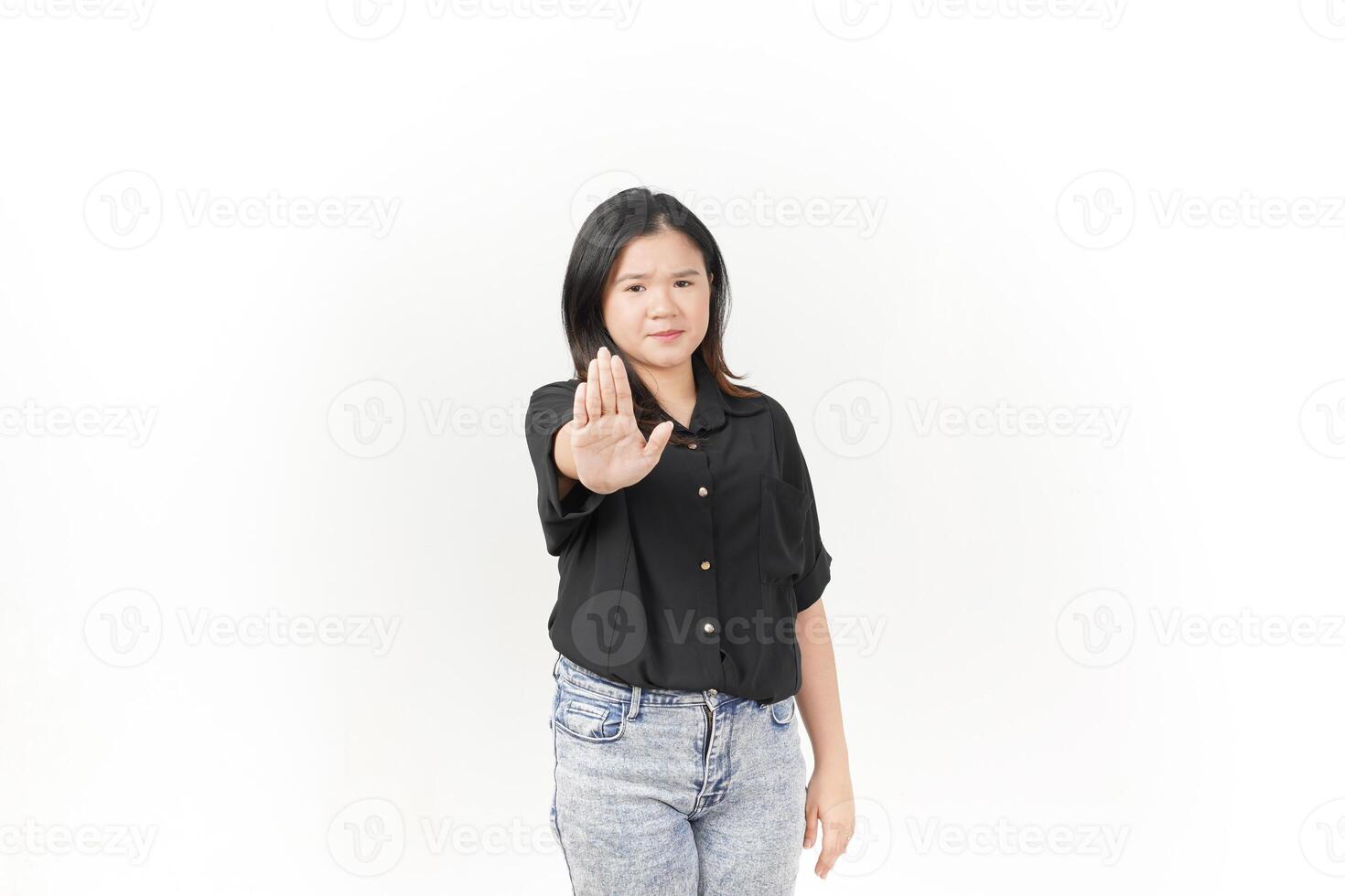 joven asiático mujer haciendo detener o rechazo firmar con palma mano vistiendo negro camiseta y pantalones aislado en blanco antecedentes foto