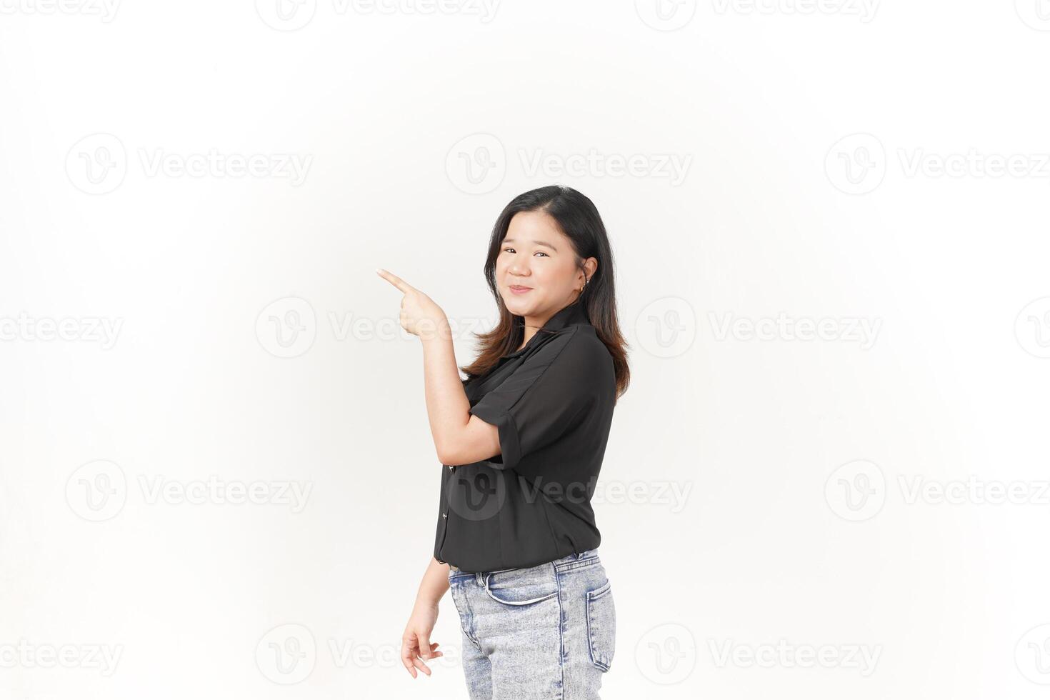 Young Asian woman Pointing aside blank copy space wearing Black t-shirt and jeans isolated on white background photo