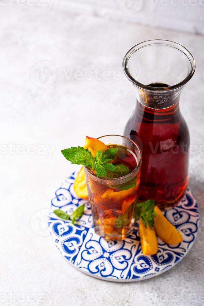 Cold ice tea with peach and mint photo