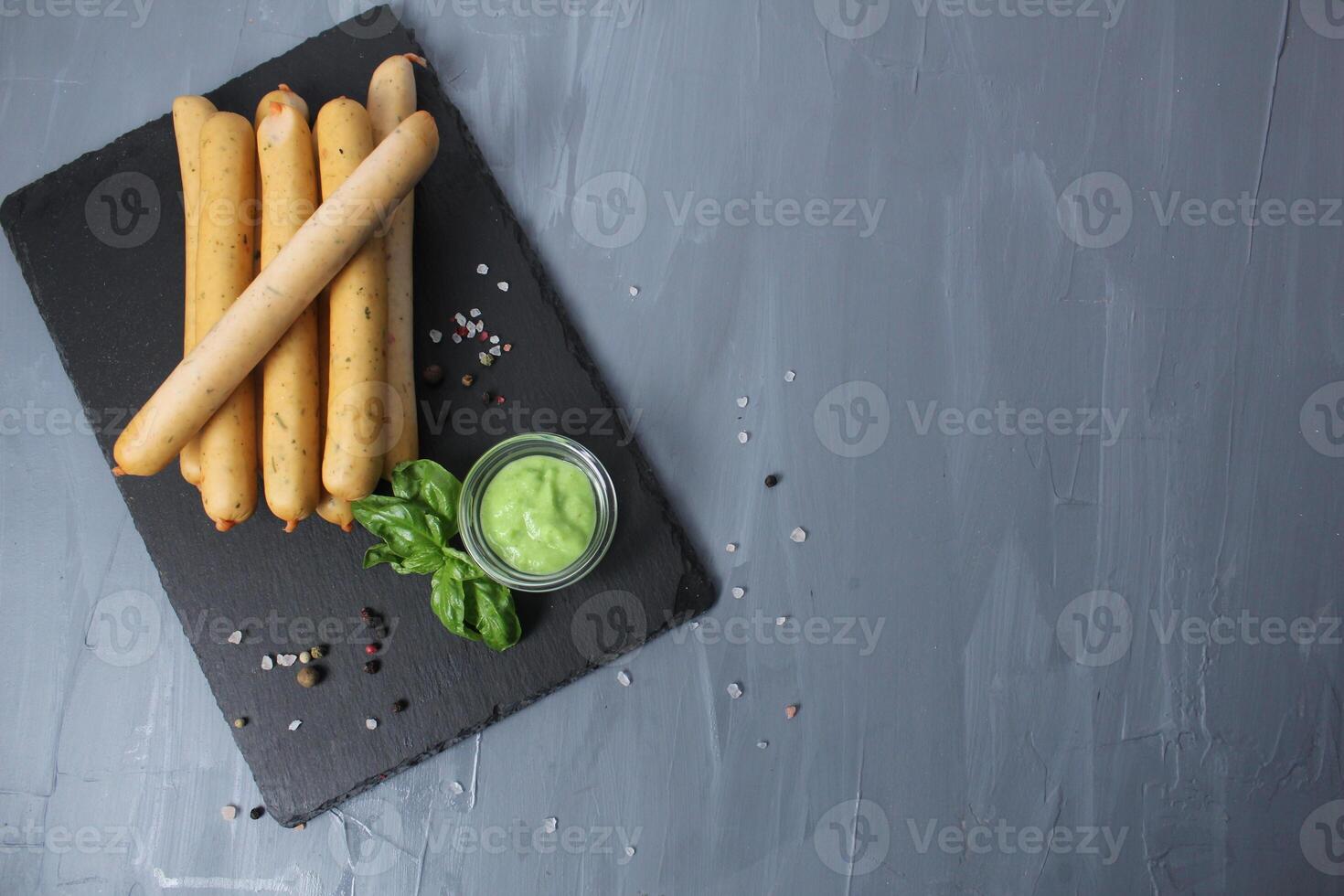 White Natural Healthy Right Sausages Without Dyes With Basil Pesto Pepper On Grey Background With Space For Copy Space Text. Sausage recipe photo