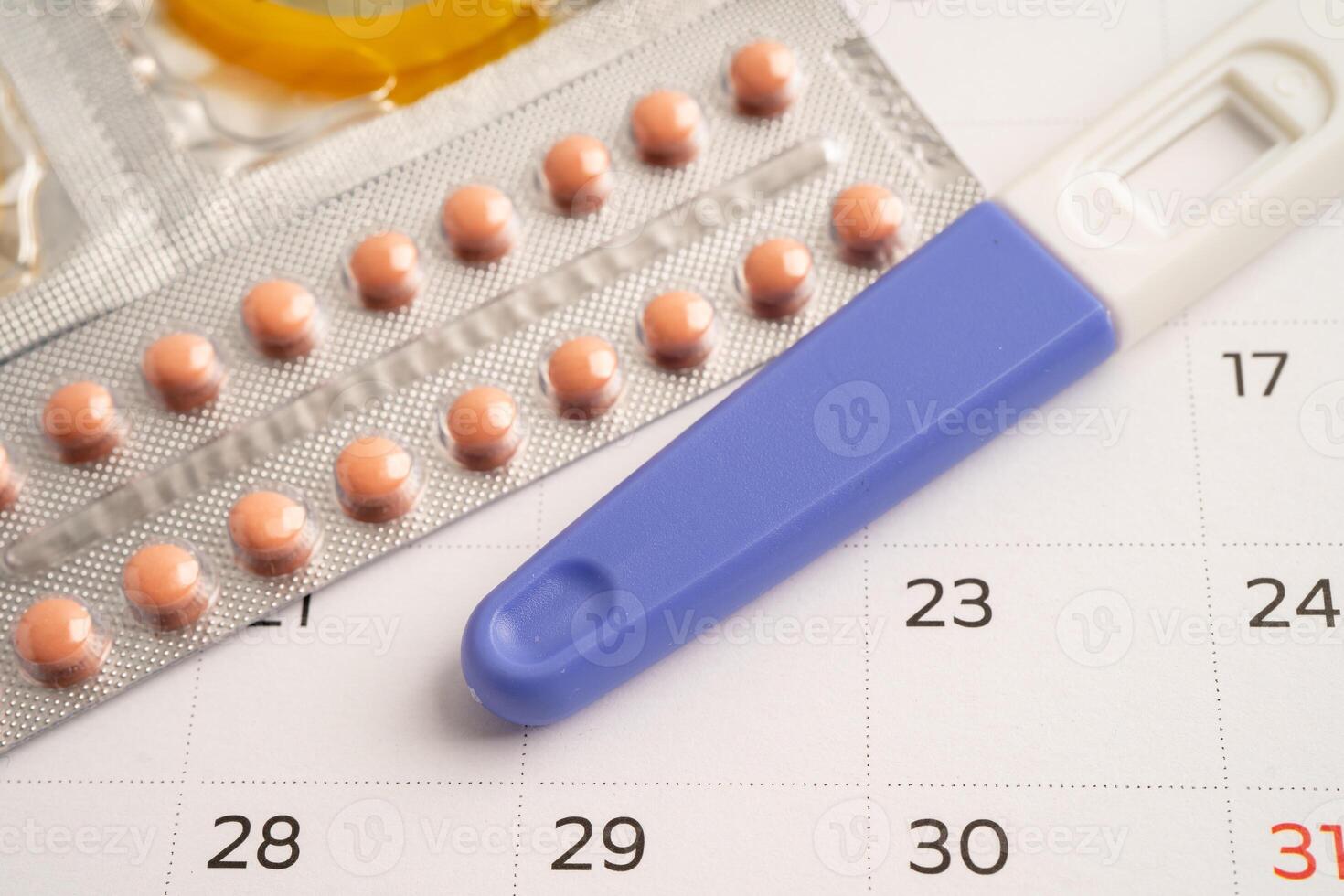 Pregnancy test and birth control pills on calendar, contraception health and medicine. photo