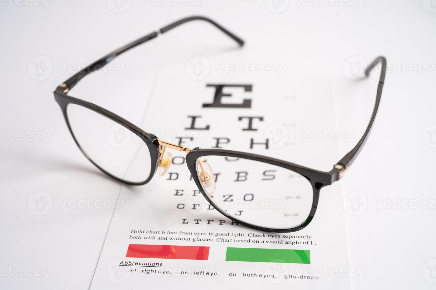 Glasses on eye testing exam chart to check eyesight accuracy of reading. photo