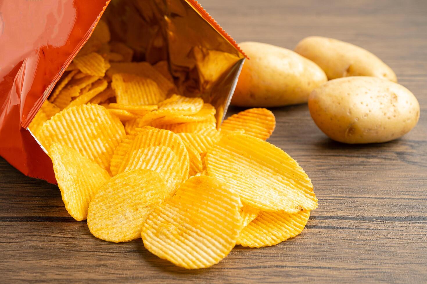 Potato chips, delicious BBQ seasoning spicy for crips, thin slice deep fried snack fast food in open bag. photo