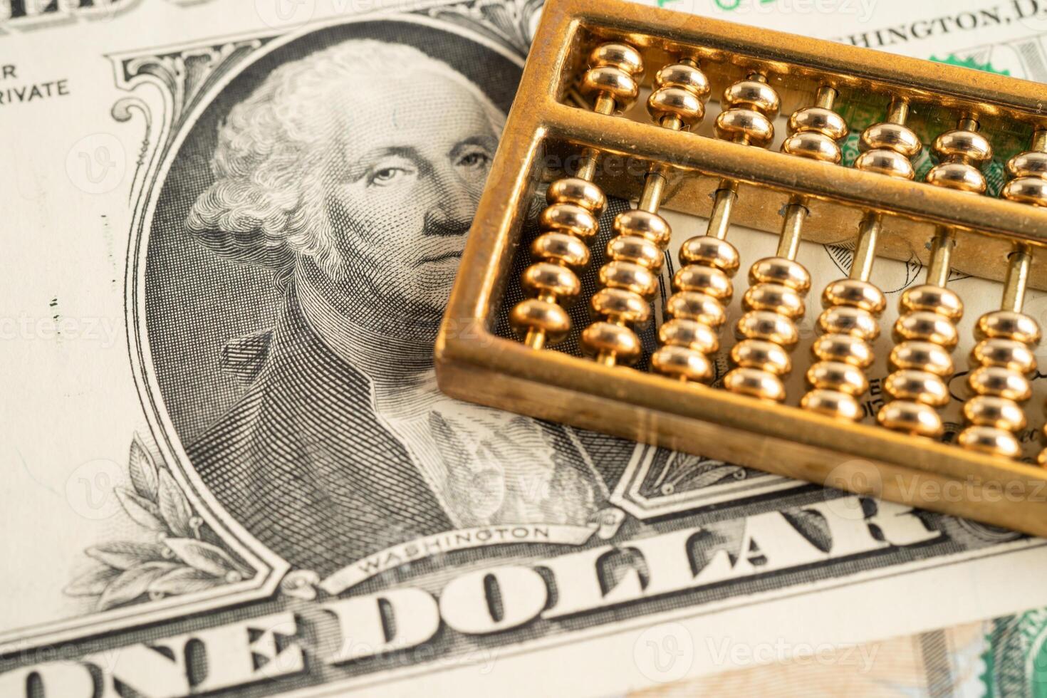 Gold abacus on US dollar banknote money, economy finance exchange trade investment. photo