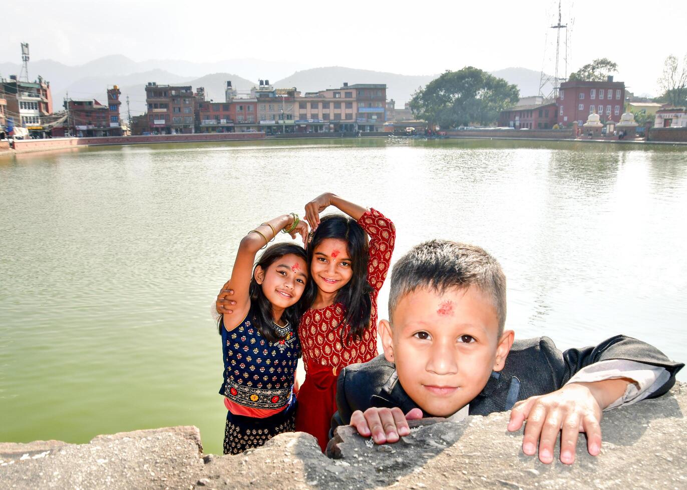 Bhaktapur, Nepal - 15th november, 2023 - nepalese kids pose outside look at camera on festival celebrations wear traditional clothes, having red bindi mark on their forehead.Dashain or Vijaya Dashami photo