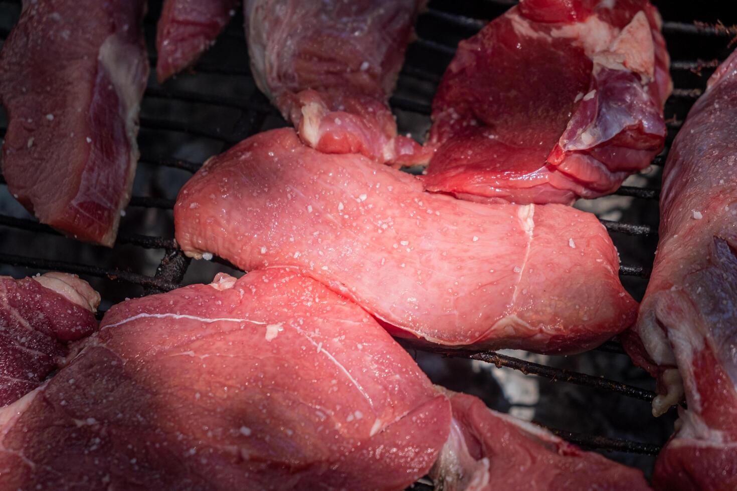high quality, organically-raised raw beef chunks on a grill for cooking photo