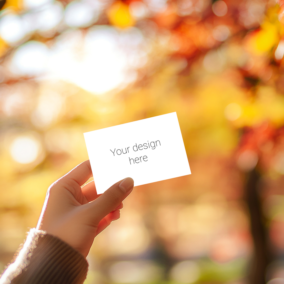 A woman holding a blank card mockup in front of a fall tree psd