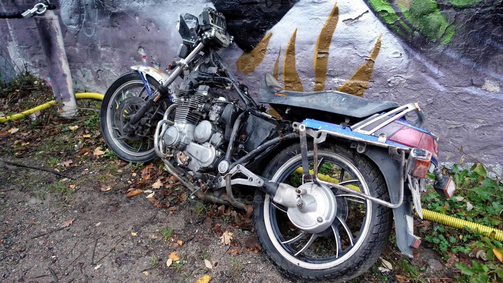 Stockholm, Snosatra, October 28, 2020. An old abandoned motorcycle leaning against a wall photo