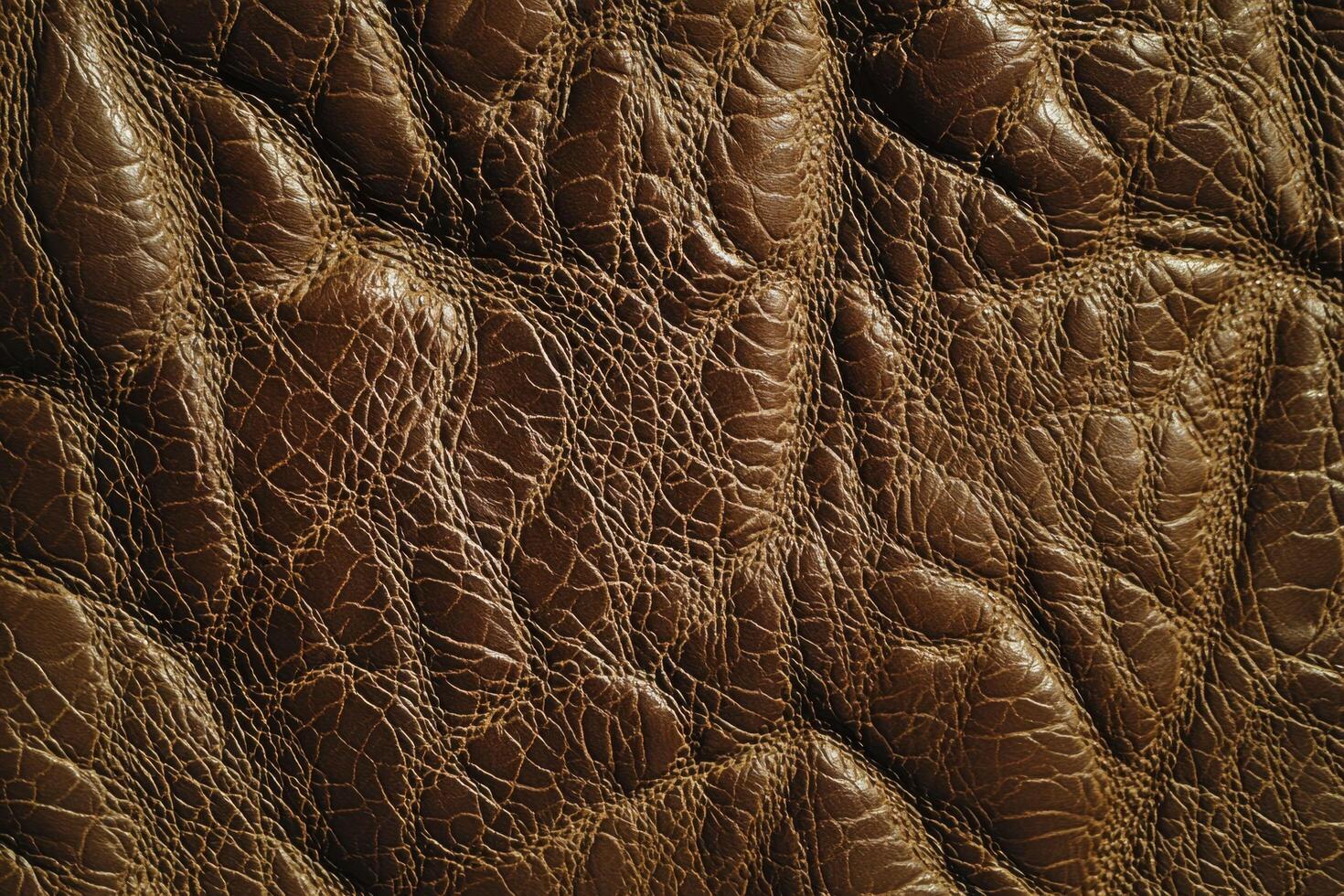 An embossed leather texture background features intricate patterns or designs raised above the surface of the leather photo