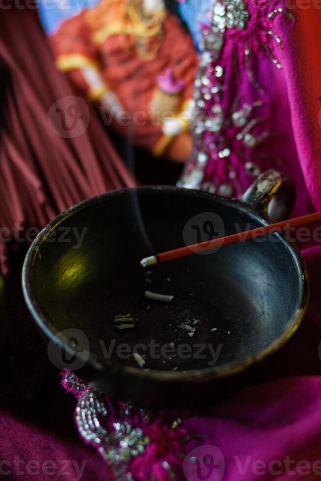 An incense stick smolders in a trickle of smoke photo